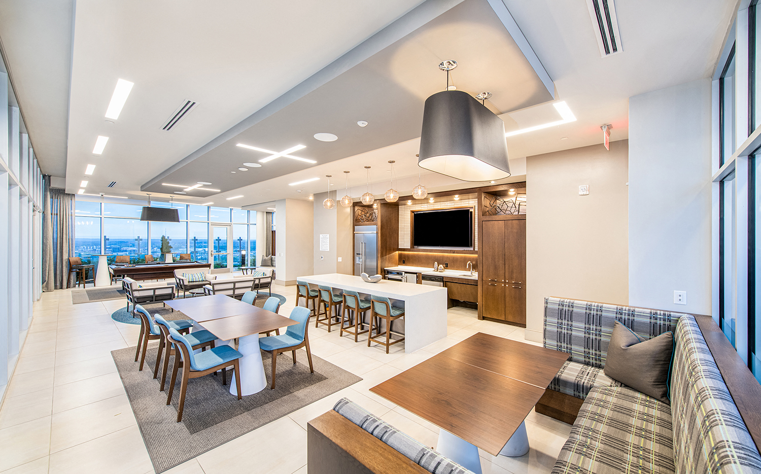 a large living room with tables and chairs and a television